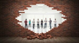 Pared de ladrillos derribada revelando grupo de personas, simbolizando la superación de barreras en la comunicación